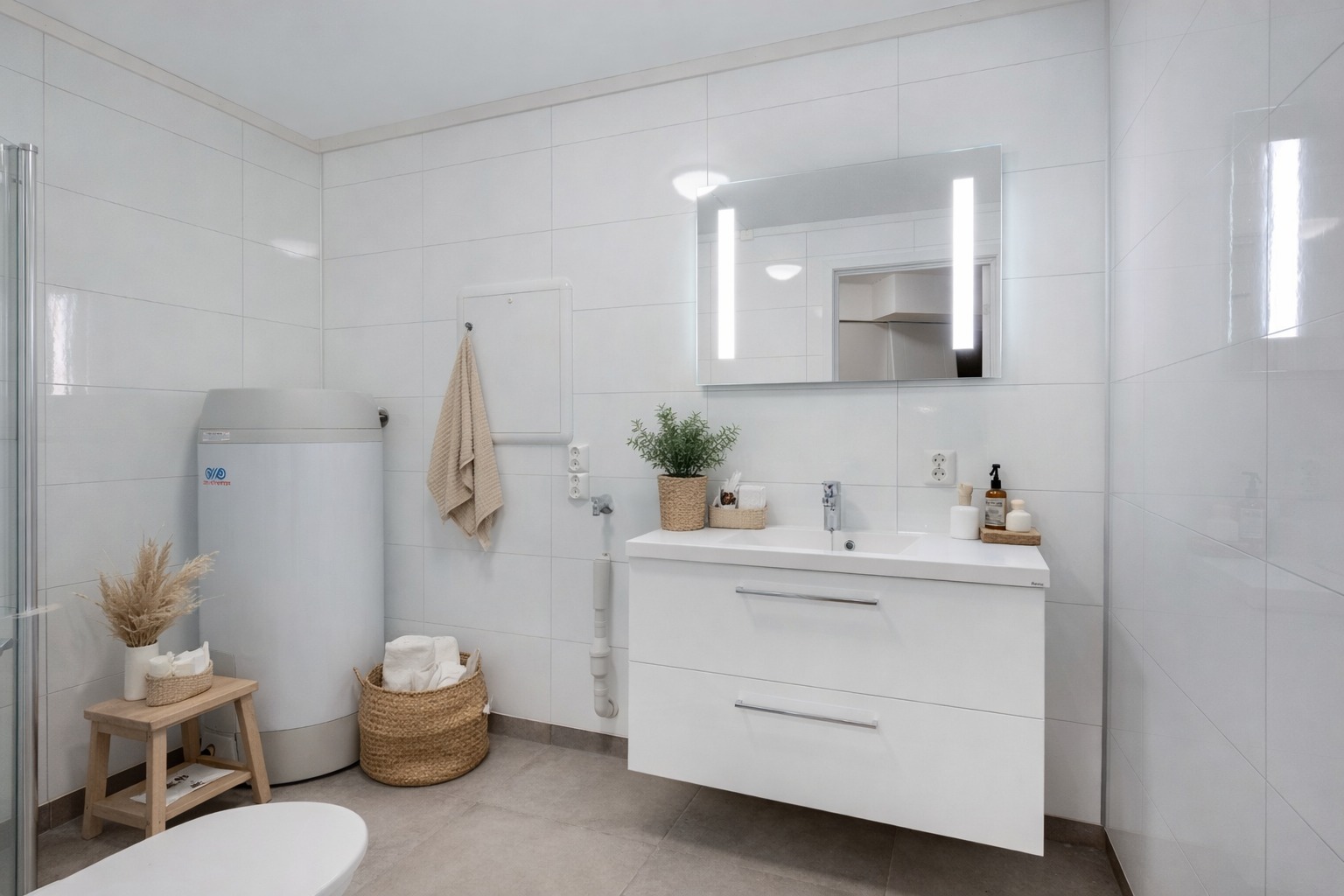 Flislagt og moderne bad med stilren innredning, god oppbevaringsplass og integrert speil med belysning. Praktisk og tidsriktig utforming.